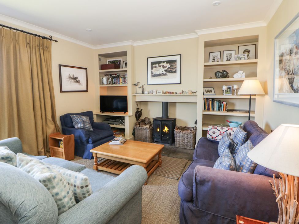 A living room with a fireplace and bookshelves at Dolwylan in Newport, Pembrokeshire