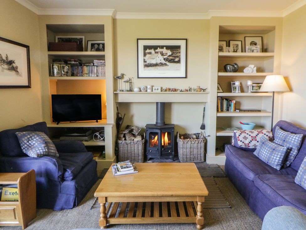 A living room with a sofa, coffee table, and fireplace at Dolwylan, Newport, Pembrokeshire