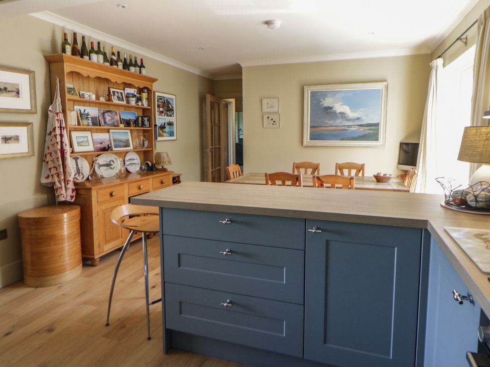A kitchen with shelves and a dining table at Dolwylan in Newport, Pembrokeshire
