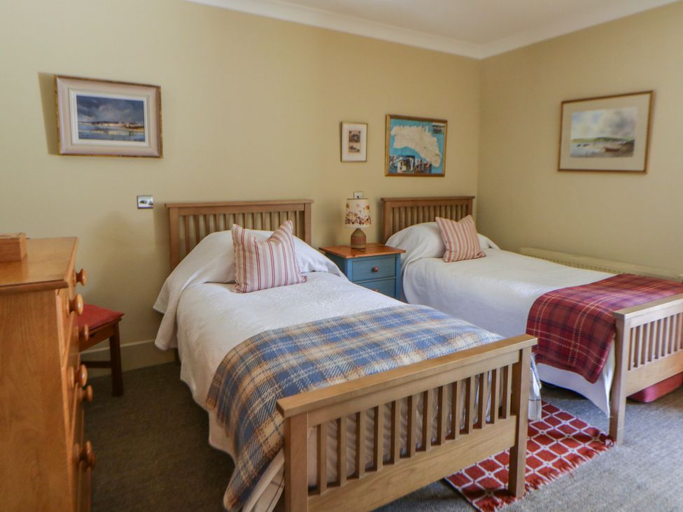 A bedroom with two single beds and a dresser at Dolwylan in Newport, Pembrokeshire