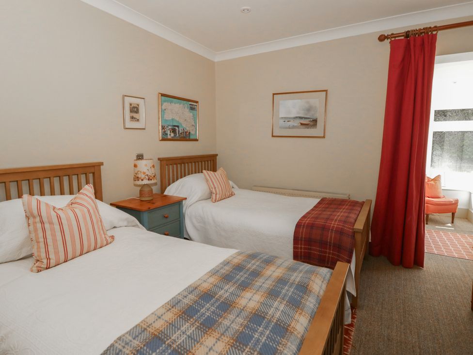 A bedroom with two single beds and a nightstand at Dolwylan in Newport, Pembrokeshire