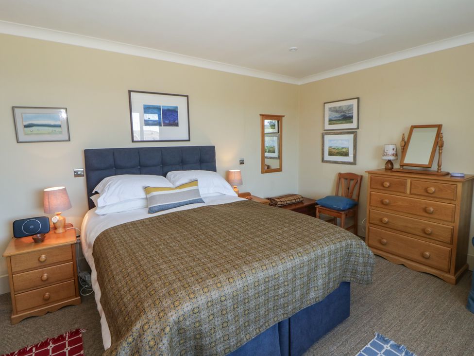 A bedroom with a bed and wooden furniture at Dolwylan in Newport, Pembrokeshire