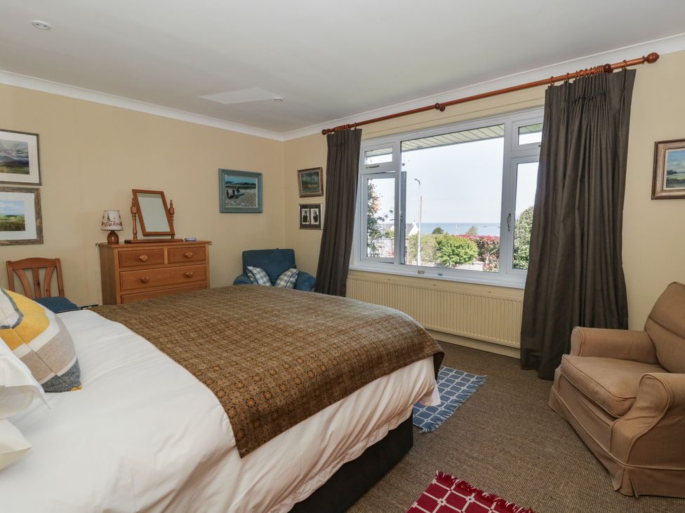 A bedroom with a bed and large window at Dolwylan in Newport, Pembrokeshire