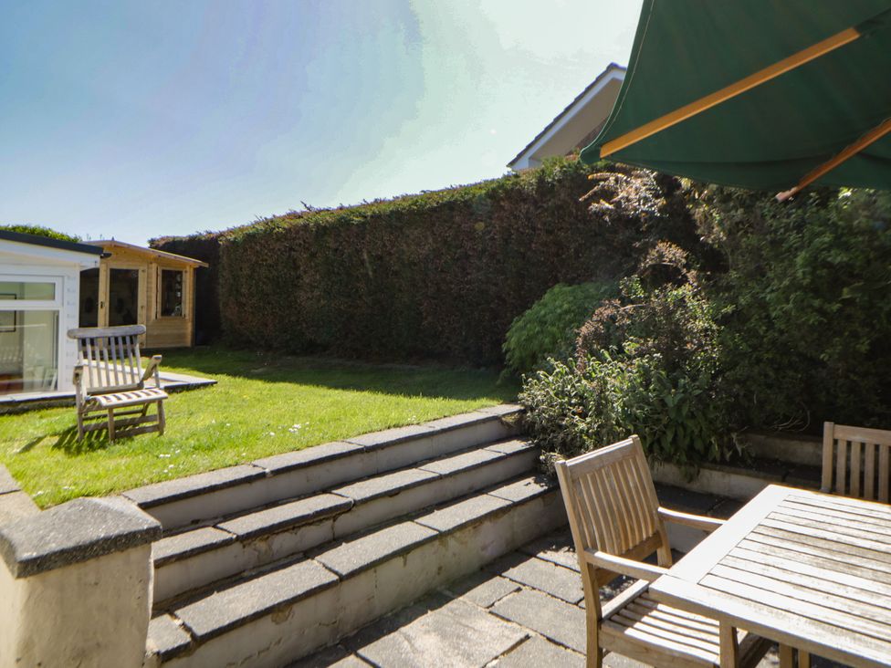 A garden with wooden chairs, table, and steps at Dolwylan in Newport, Pembrokeshire