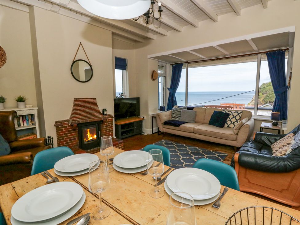 A living room with a sofa and fireplace at Delyn Aur in Tresaith, Ceredigion