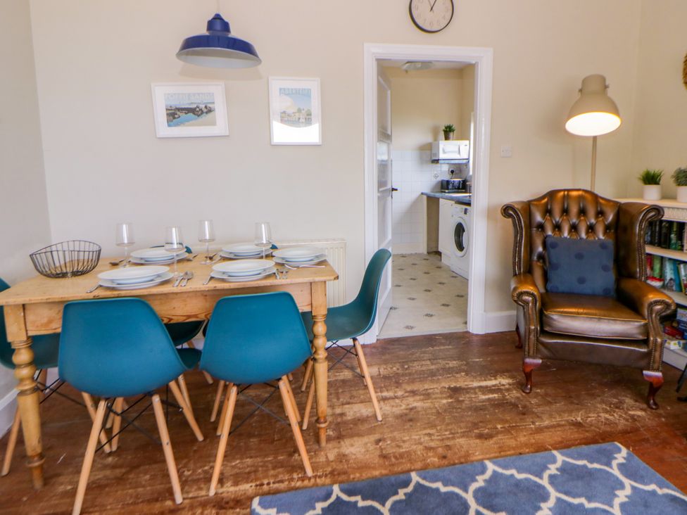 A dining room with a wooden table and chairs at Delyn Aur, Tresaith, Ceredigion