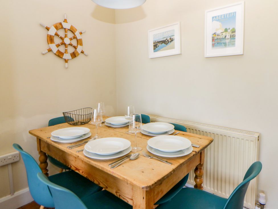 A dining room with a table set for dinner at Delyn Aur, Tresaith, Ceredigion