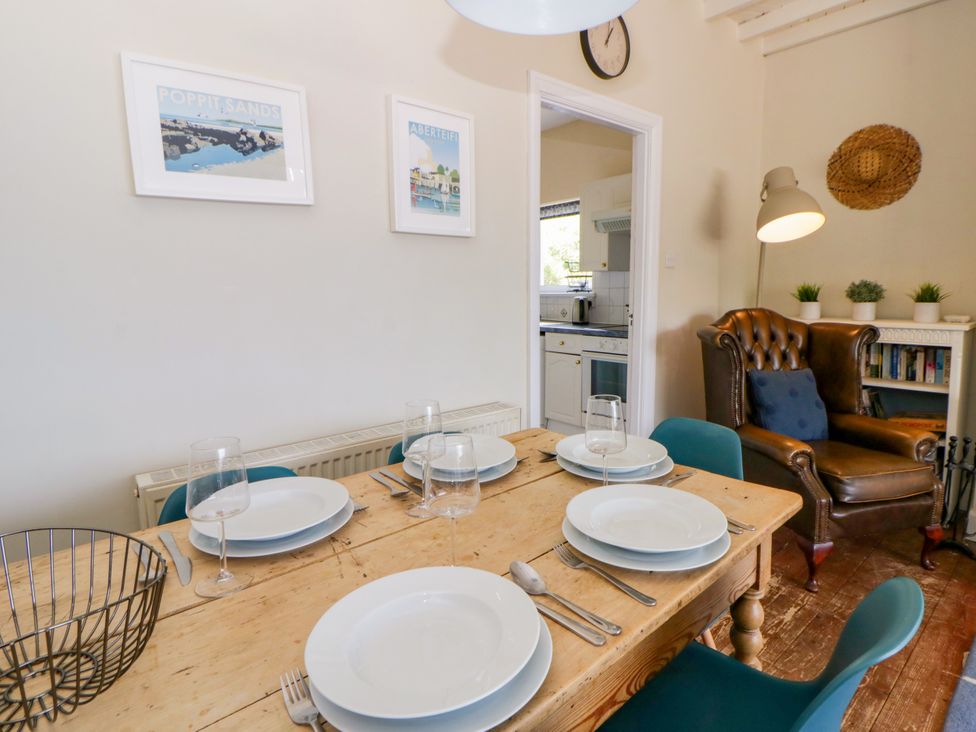 A dining room with a table set for a meal at Delyn Aur Tresaith, Ceredigion