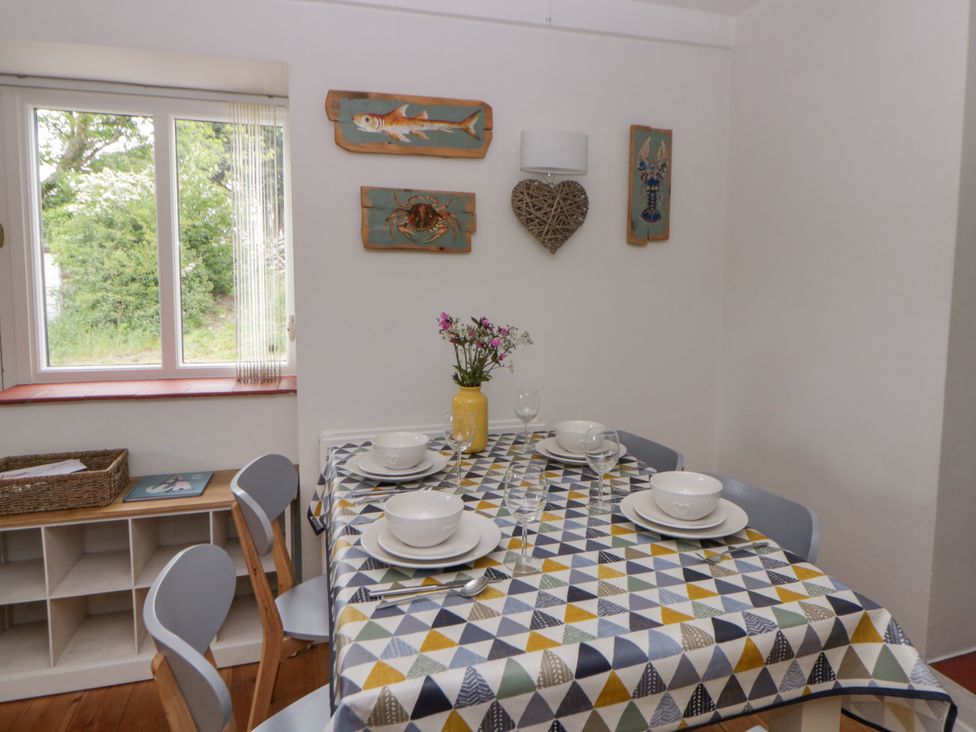 A dining room with a table set for meals at Little Barn Cottage Dinas Cross Pembrokeshire