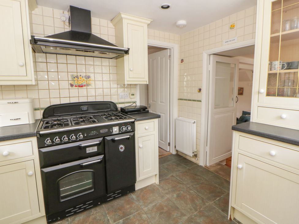 A kitchen with a cooker and cabinets at Little Barn Cottage, Dinas Cross, Pembrokeshire
