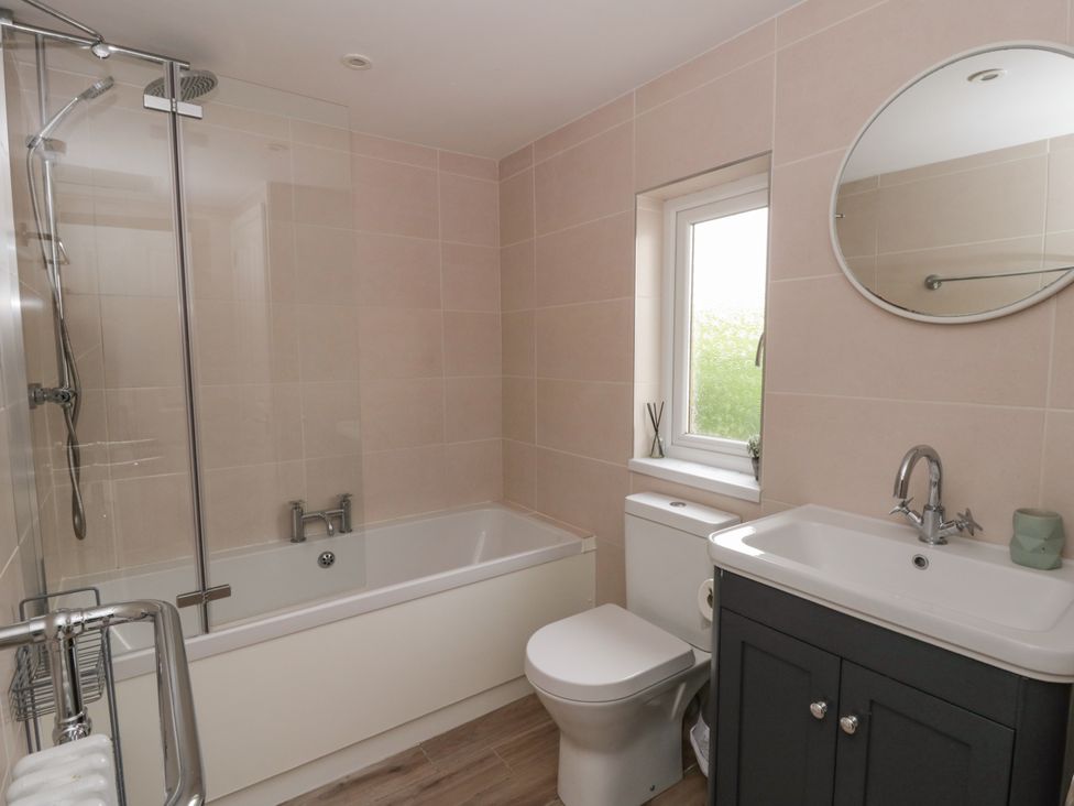 A bathroom with a shower, bath, toilet, and sink at Little Barn Cottage, Dinas Cross, Pembrokeshire
