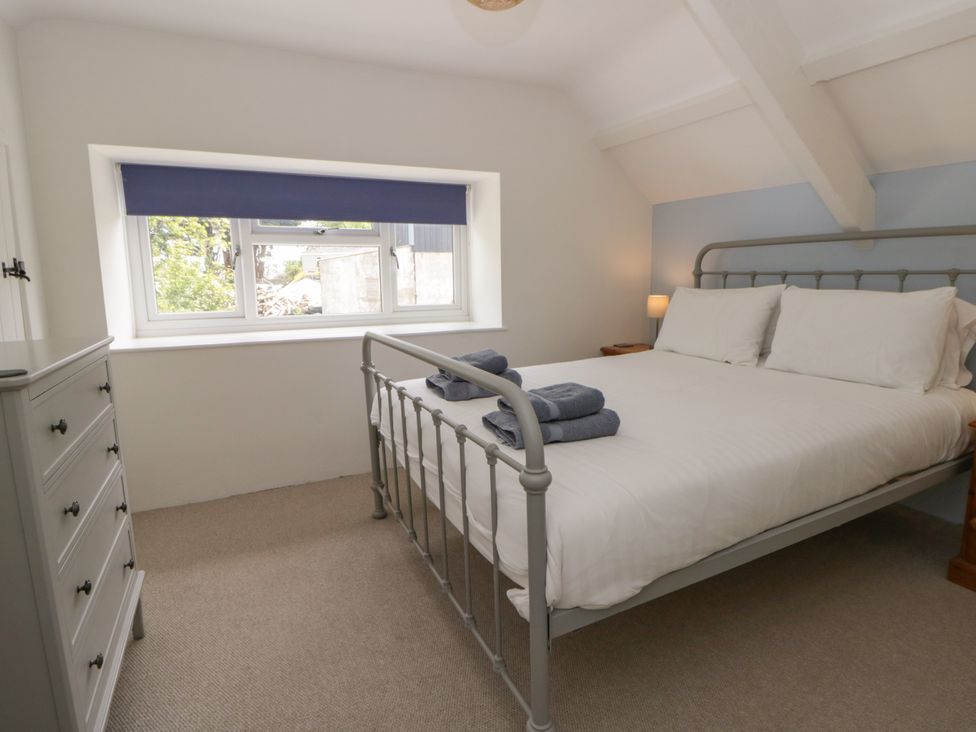 A bedroom with a bed and dresser at Little Barn Cottage in Dinas Cross, Pembrokeshire