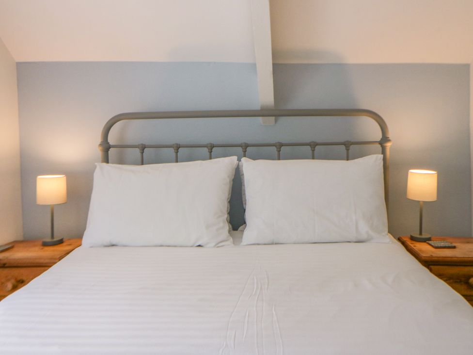 A bedroom with a bed and bedside lamps at Little Barn Cottage, Dinas Cross, Pembrokeshire