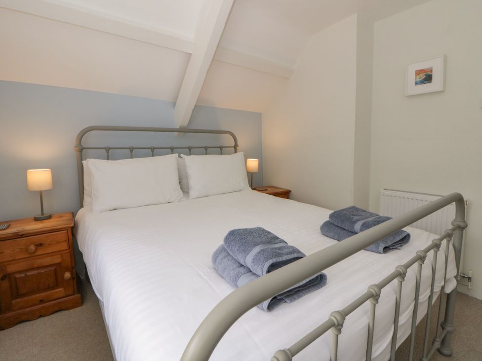 A bedroom with a bed and bedside tables at Little Barn Cottage, Dinas Cross, Pembrokeshire