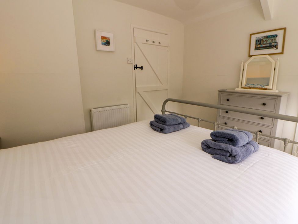 A bedroom with a bed and towels on it at Little Barn Cottage, Dinas Cross, Pembrokeshire