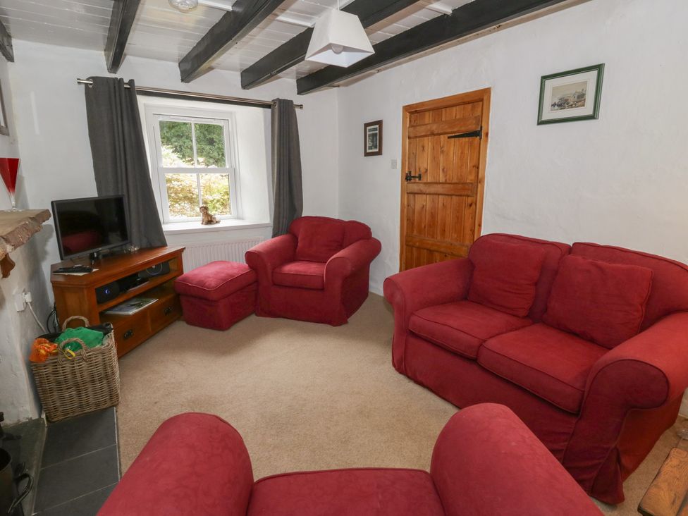 A living room with red sofas and a television at Panteg, Cardigan Llangoedmor Cardigan