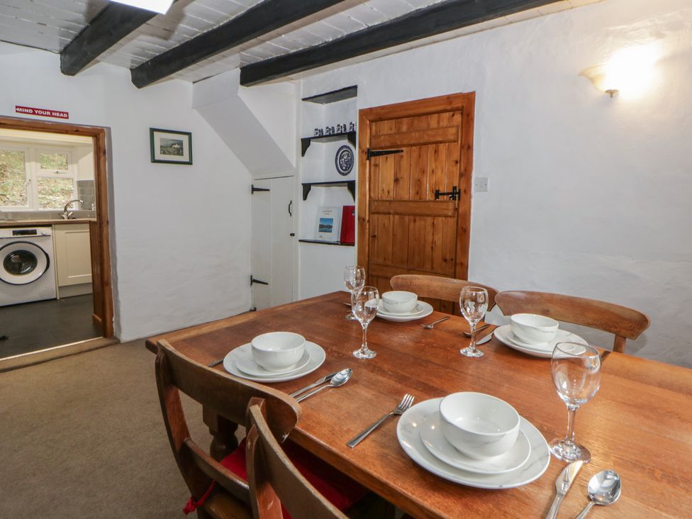 A dining room with a wooden table and place settings at Panteg, Cardigan Llangoedmor Cardigan