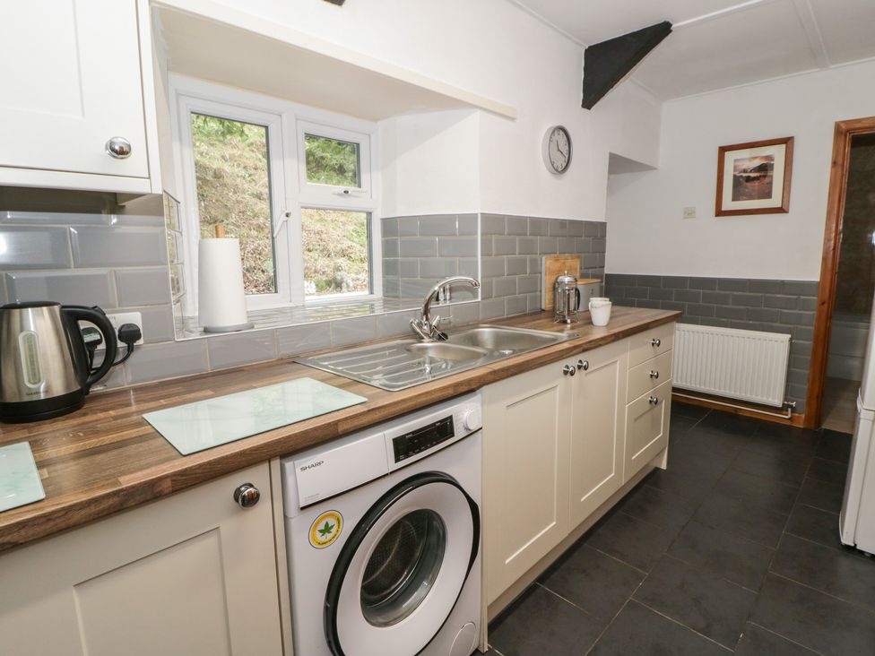 A kitchen with a sink, kettle, and washing machine at Panteg, Cardigan Llangoedmor Cardigan