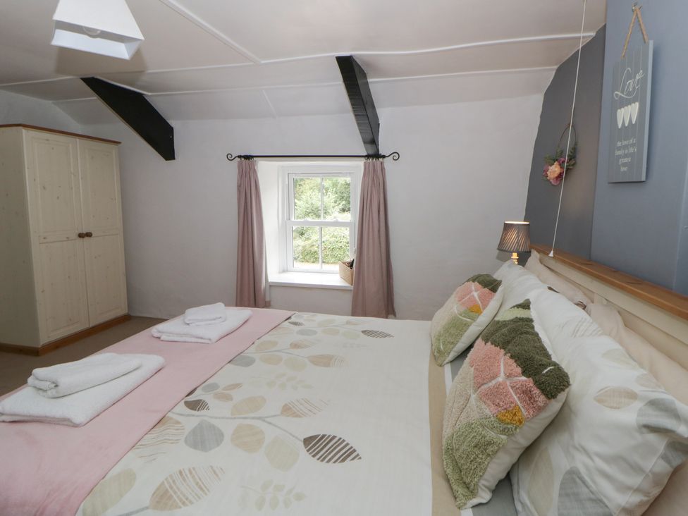 A bedroom with a bed and wardrobe at Panteg, Cardigan Llangoedmor Cardigan