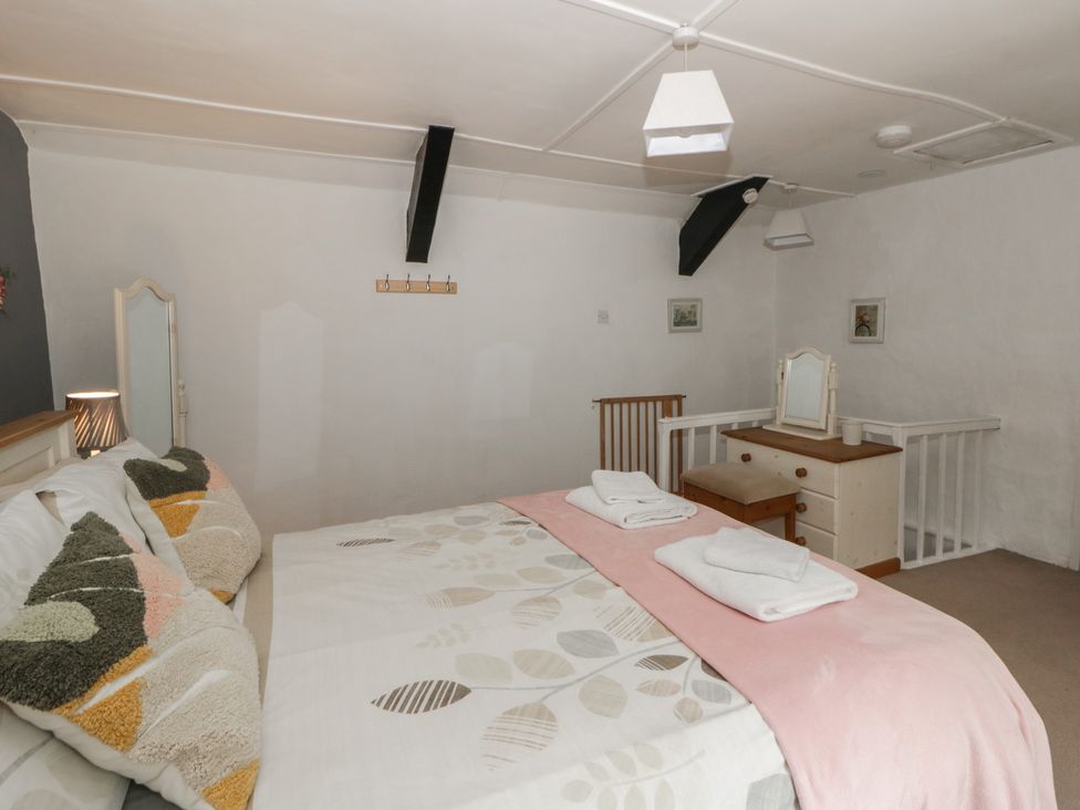 A bedroom with a bed and dresser at Panteg, Cardigan Llangoedmor Cardigan