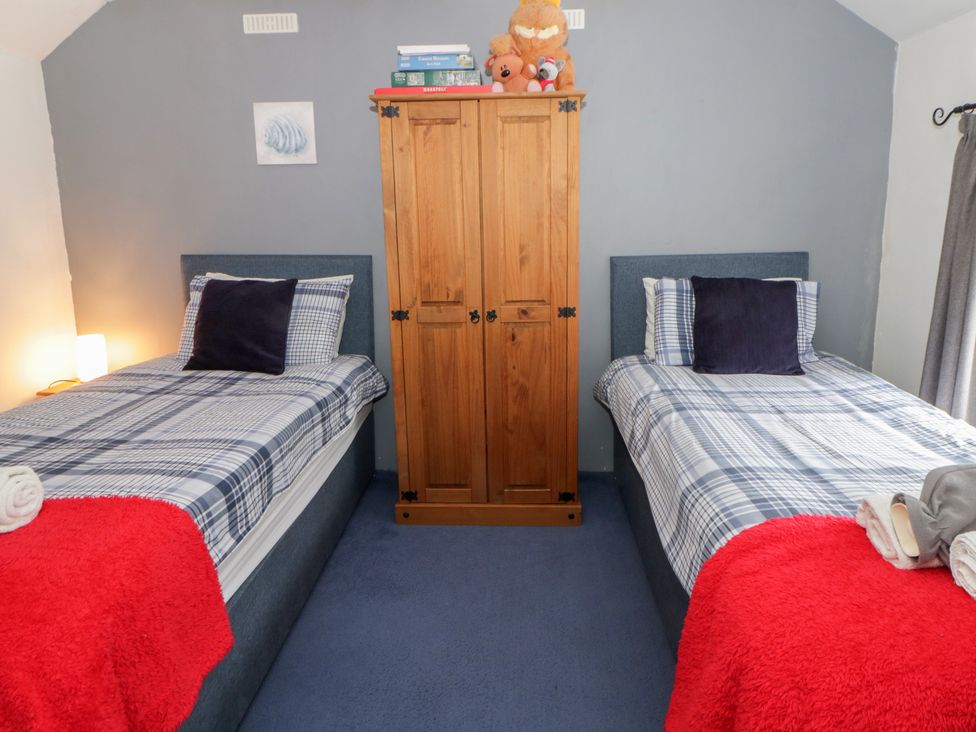 A bedroom with two single beds and a wardrobe at Panteg, Cardigan Llangoedmor Cardigan