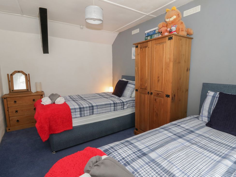 A bedroom with two beds and a wardrobe at Panteg, Cardigan Llangoedmor Cardigan