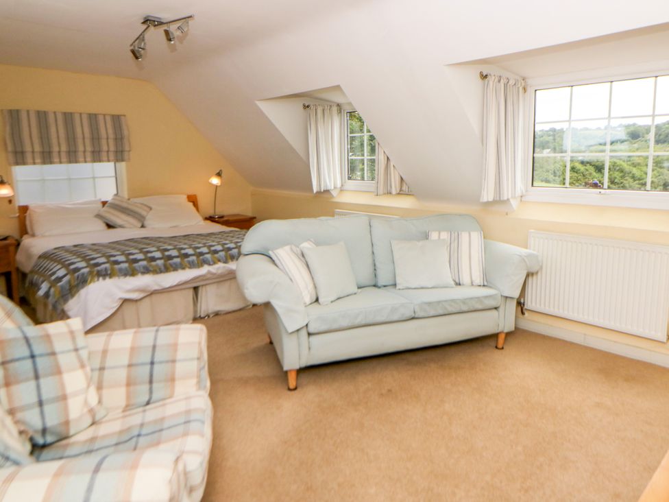 A bedroom with a bed and seating area at Beach Retreat Aberporth