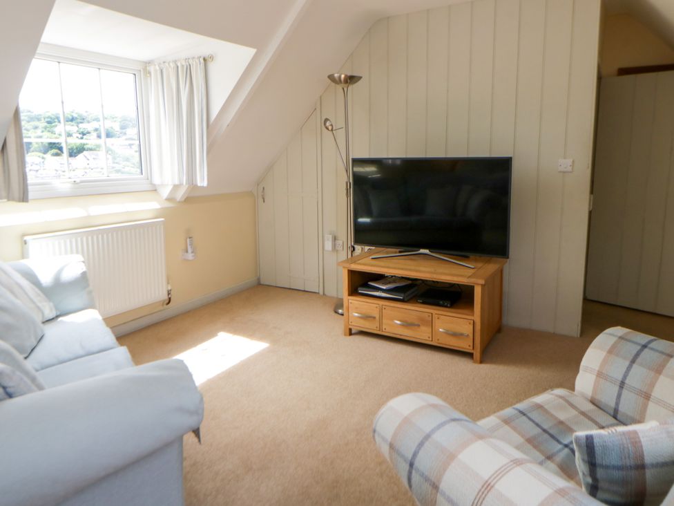 A living room with a television on a stand at Beach Retreat in Aberporth
