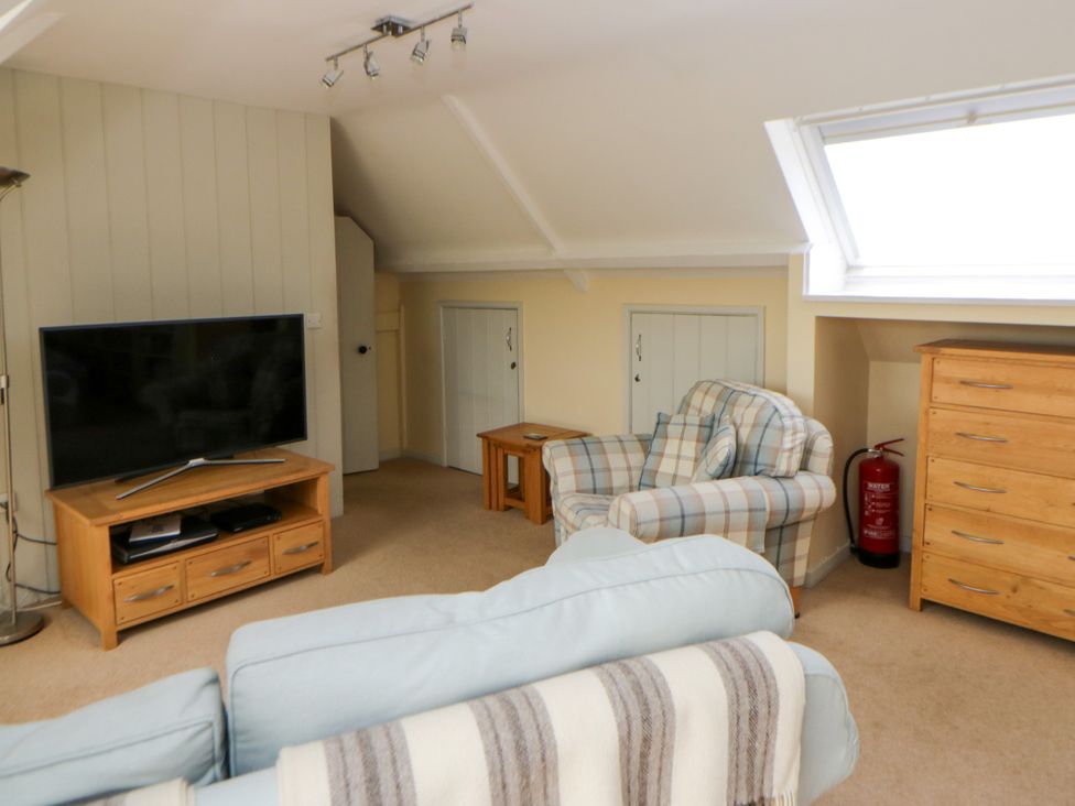 A living room with a television and armchair at Beach Retreat in Aberporth