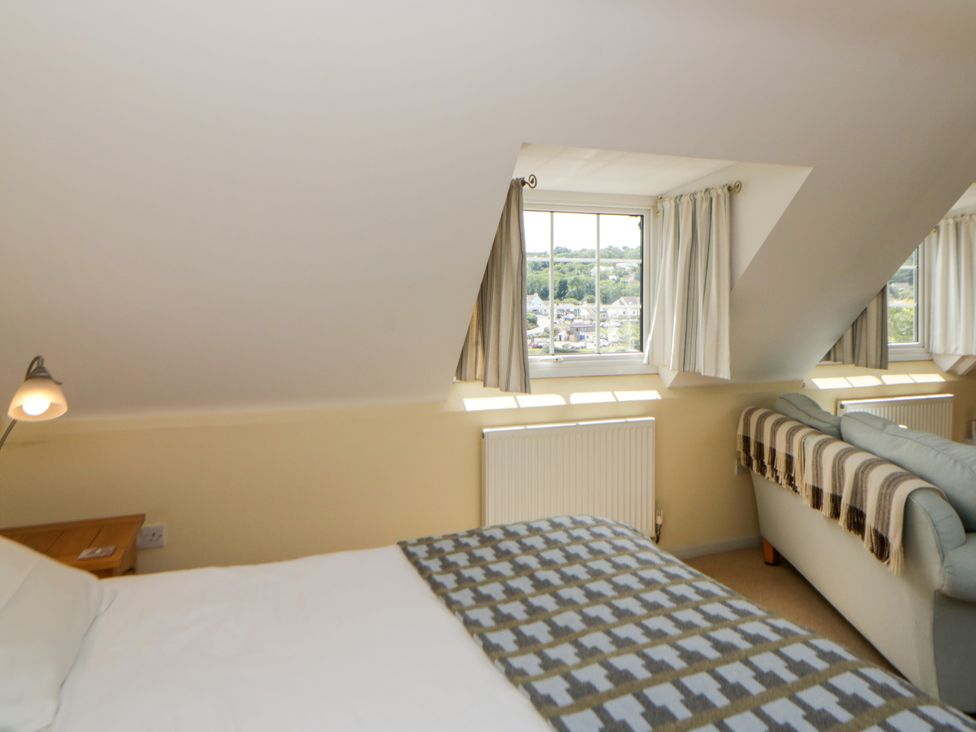 A bedroom with a bed and a sofa at Beach Retreat in Aberporth