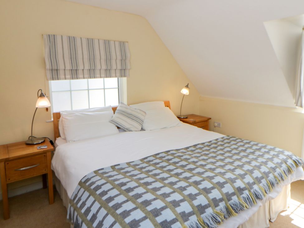 A bedroom with a double bed and bedside table at Beach Retreat in Aberporth