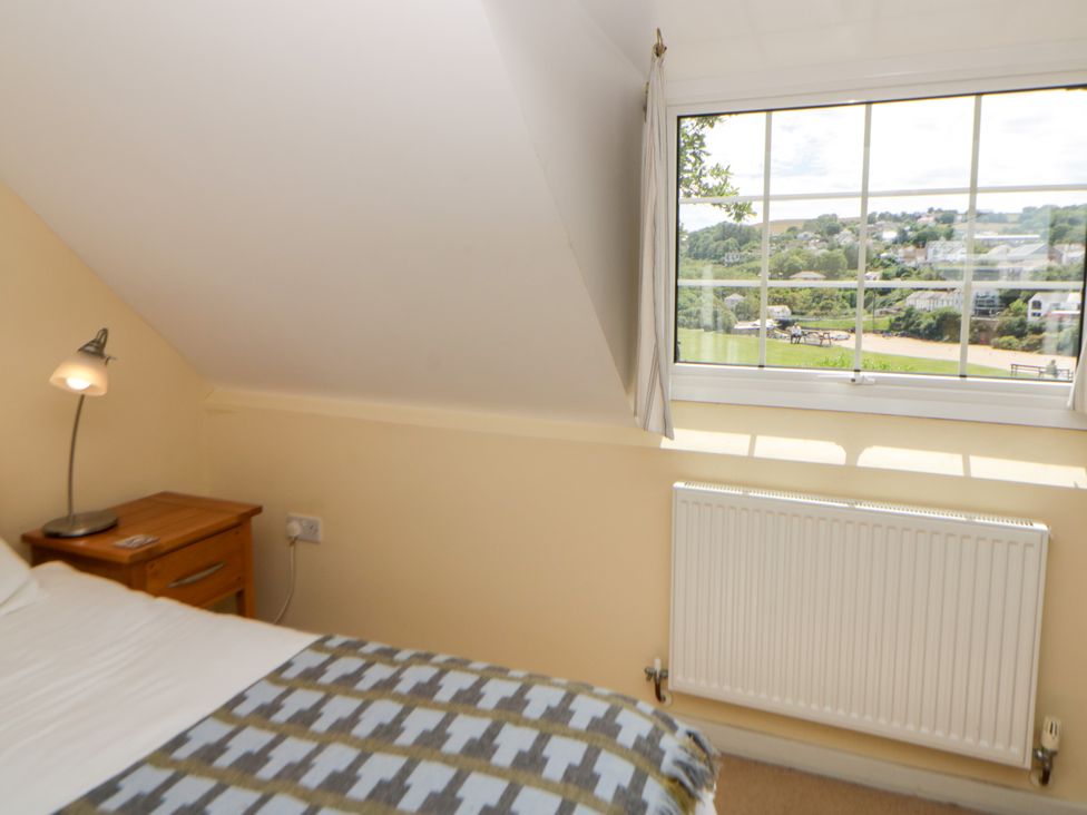 A bedroom with a bed and lamp at Beach Retreat in Aberporth
