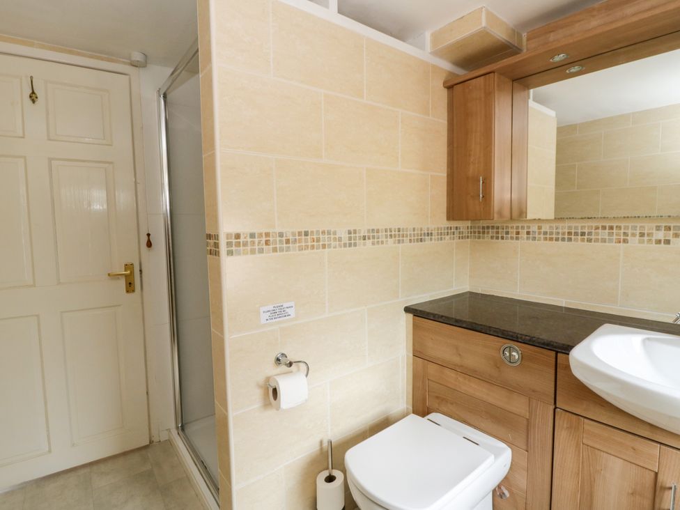 A bathroom with a shower and sink at Beach Retreat in Aberporth