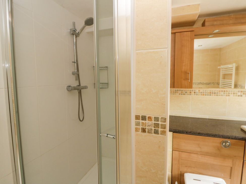 A bathroom with a shower and sink at Beach Retreat in Aberporth