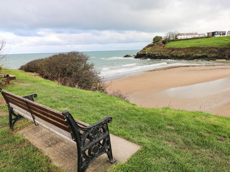 A beach view with a bench and grass at Beach Retreat in Aberporth