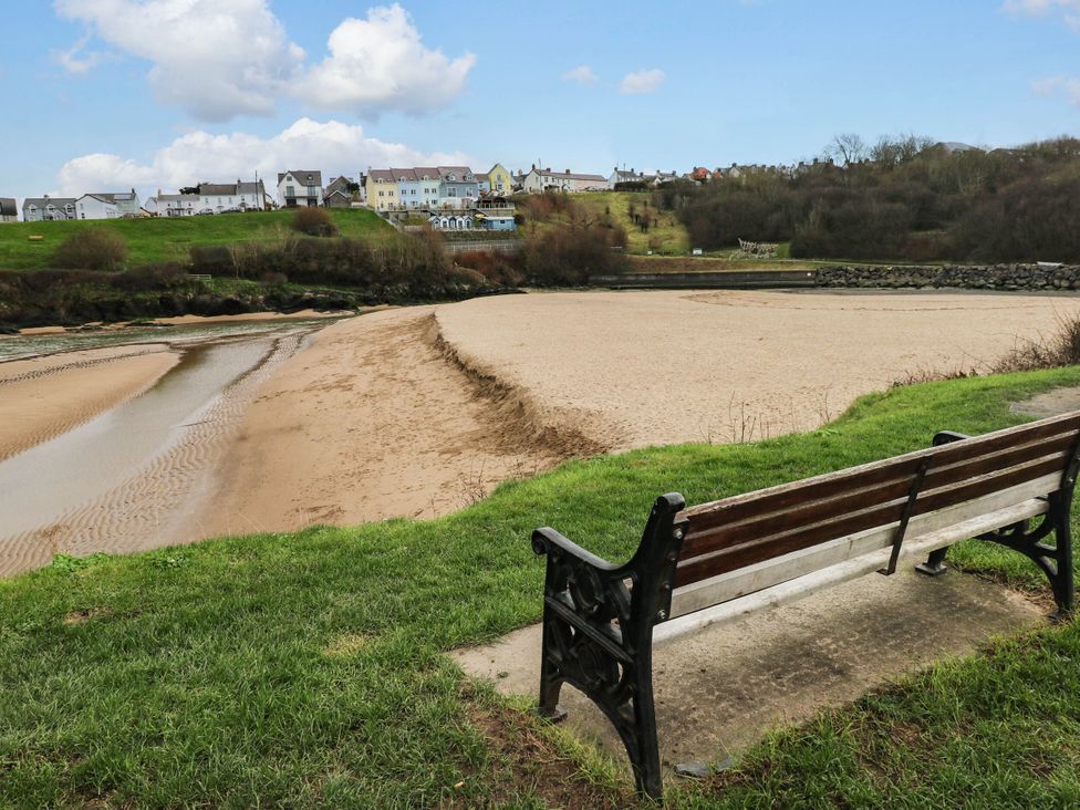 A view of a sandy area and a bench at Beach Retreat in Aberporth