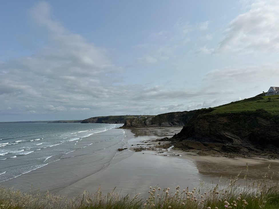 A beach with cliffs and sea at Beach Cottage in Little Haven, Pembrokeshire