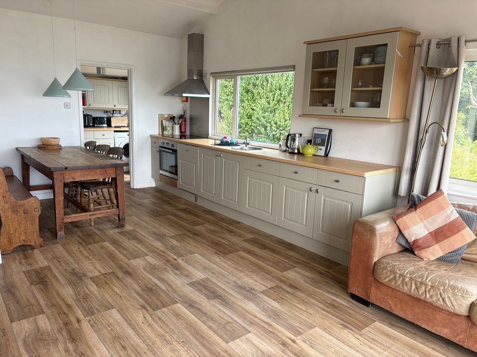 A kitchen with a table and chairs and a sofa at Beach Cove Freshwater East, Pembrokeshire