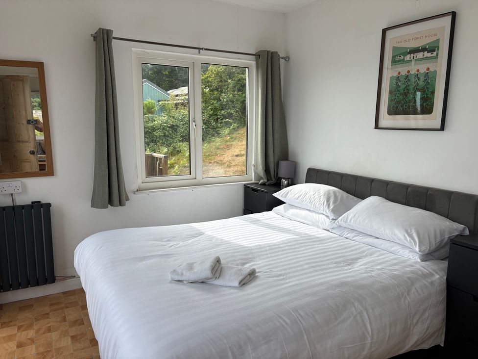 A bedroom with a double bed and window at Beach Cove Freshwater East, Pembrokeshire
