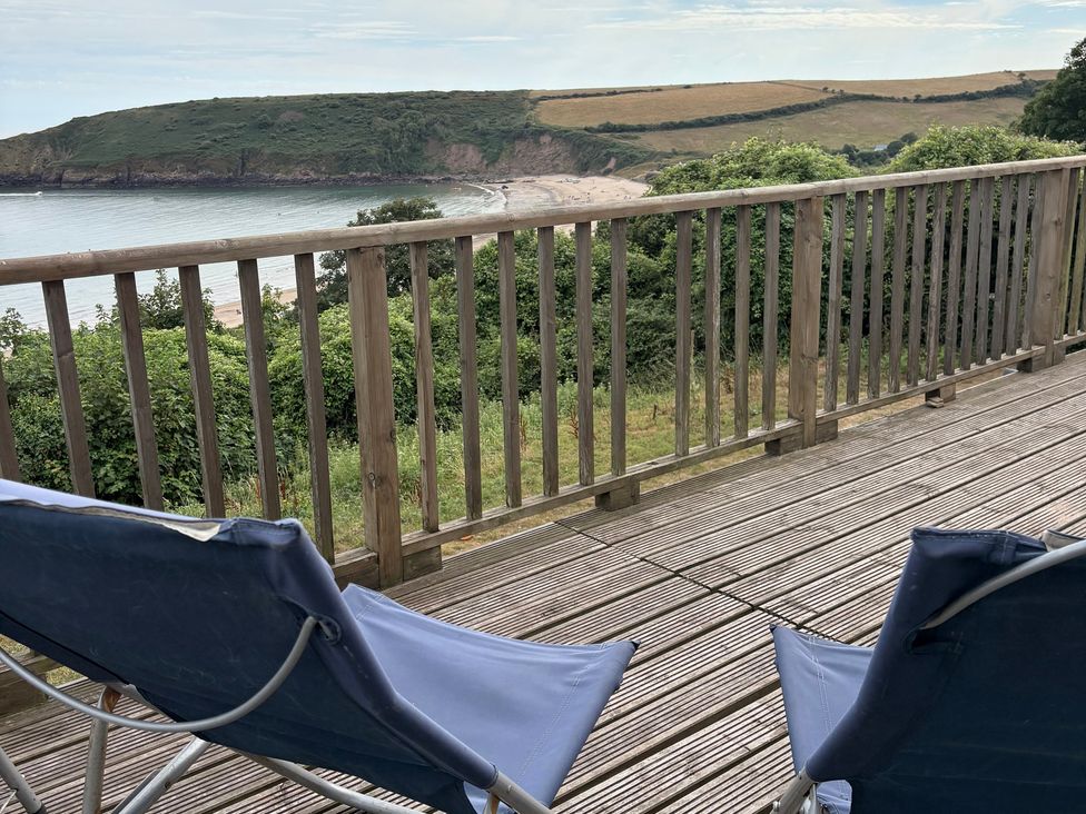 An outdoor area with chairs overlooking the sea at Beach Cove, Freshwater East, Pembrokeshire