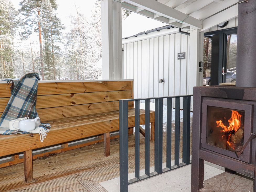 An outdoor seating area with a bench and stove at Osprey Apartment in Aviemore