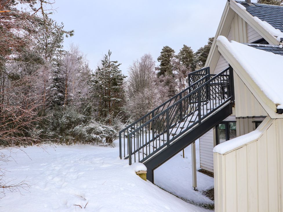 A building with stairs in snow at Osprey Apartment in Aviemore