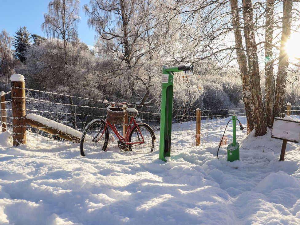 A bicycle and bike pump in snow at Osprey Apartment in Aviemore