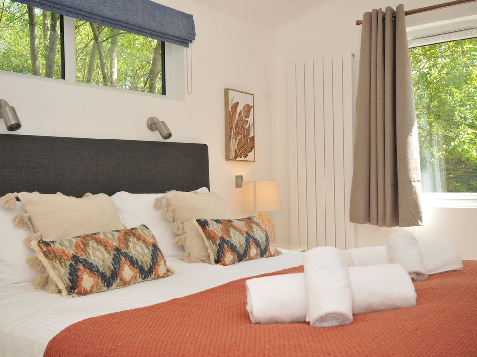 A bedroom with a bed and pillows at The Hideout in Lanreath
