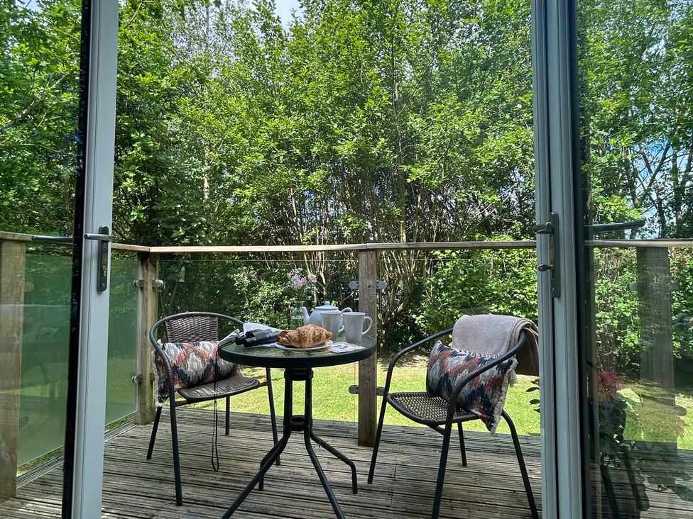 An outdoor seating area with a table and chairs at The Hideout in Lanreath