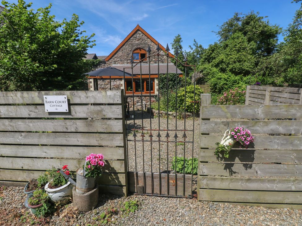 An entrance with a gate and flowers at Barn Court Cottage Narberth, Pembrokeshire