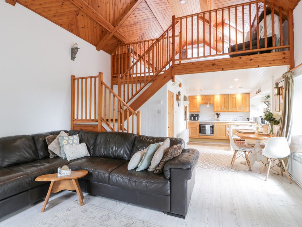 A living room with a sofa and staircase at The Barn in Rockcliffe