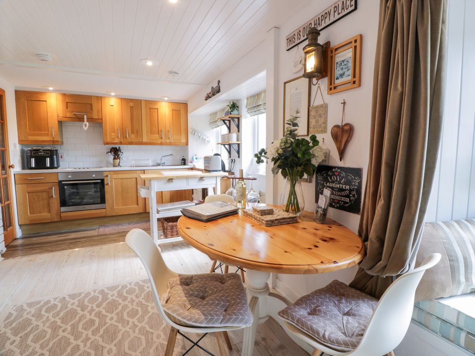A kitchen with wooden cabinets and a dining table at The Barn in Rockcliffe
