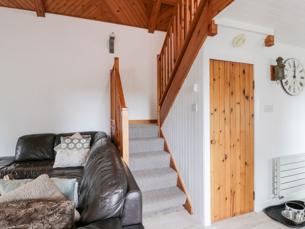A living room with a staircase and sofa at The Barn in Rockcliffe