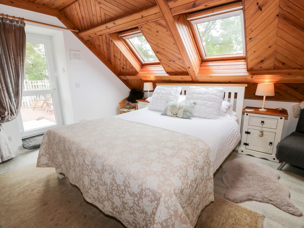 A bedroom with a bed and window at The Barn in Rockcliffe